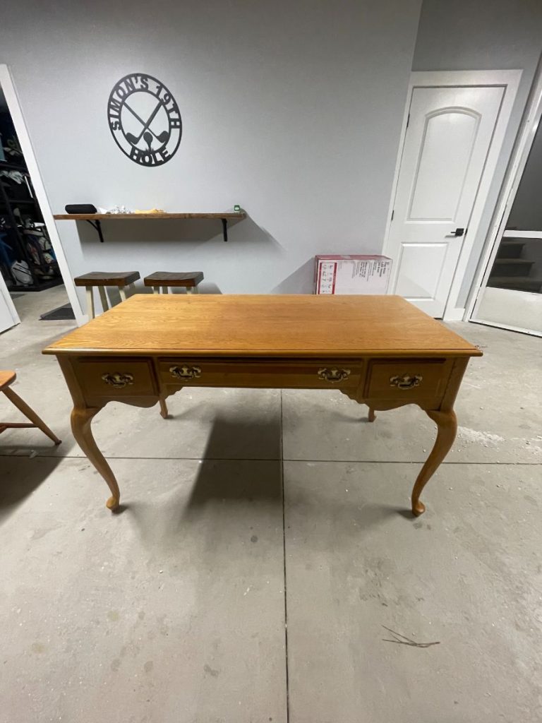Fully restored wooden writing desk with a natural warm wood stain finish, completed by Simons Painting & Drywall