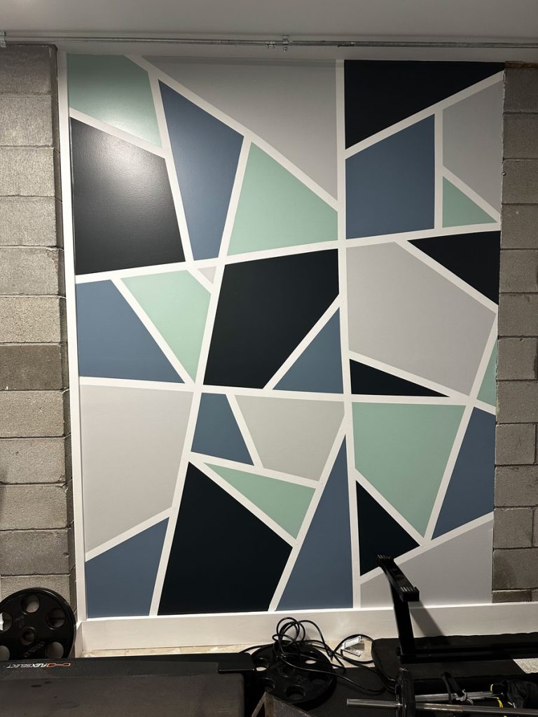Creative geometric accent wall with multi-colored custom painting for an interior space in Connecticut, by Simons Painting & Drywall.