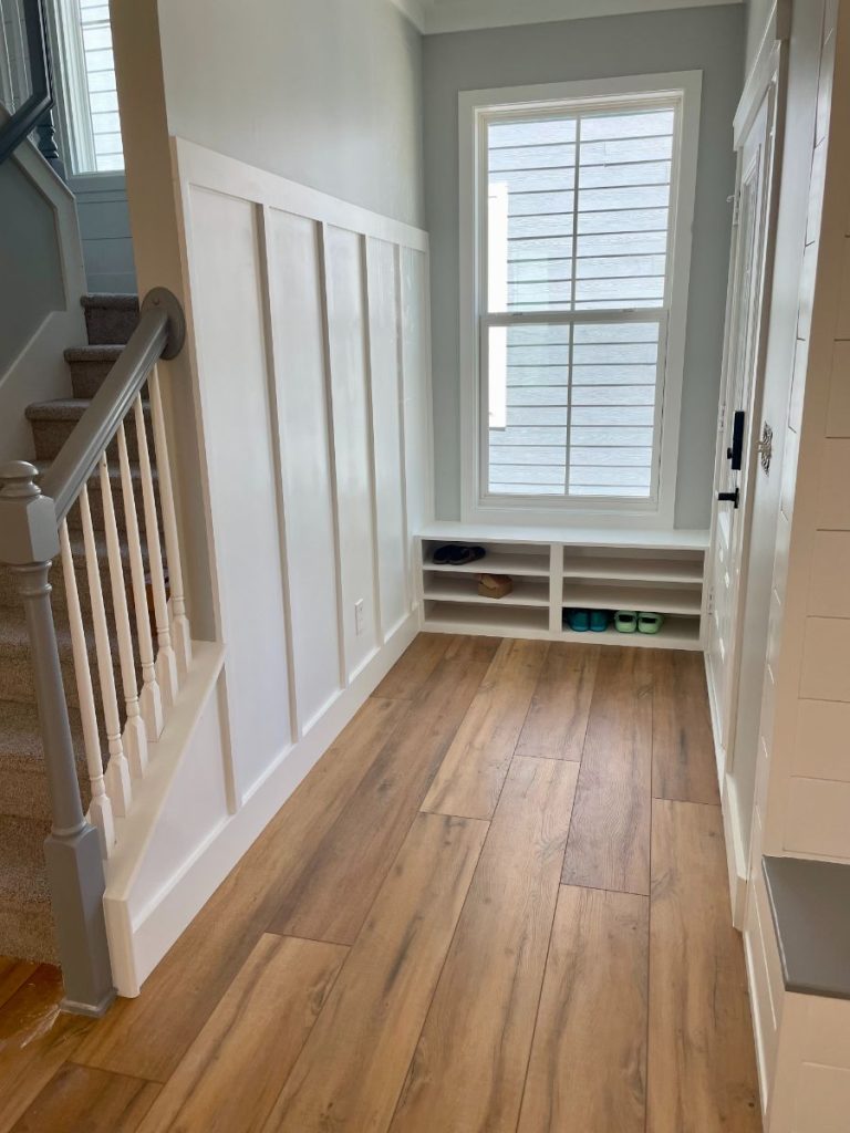 Entryway mudroom featuring custom white board and batten wall paneling and built-in bench seating