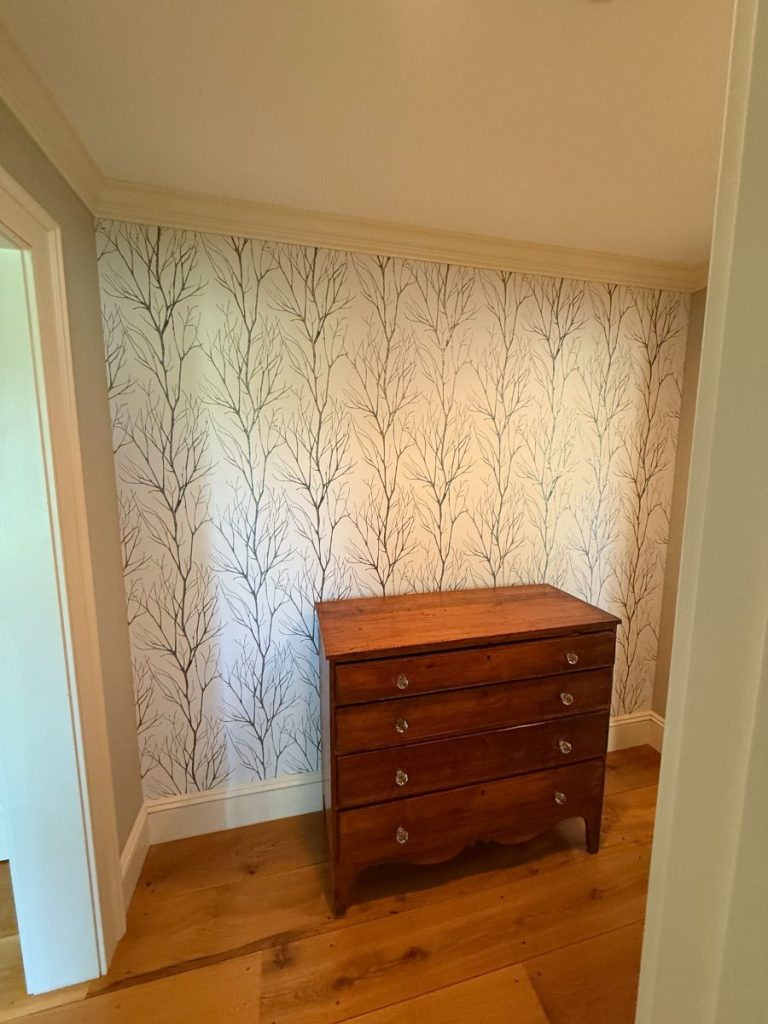 Accent wall with newly installed tree-patterned wallpaper by Simons Painting & Drywall.